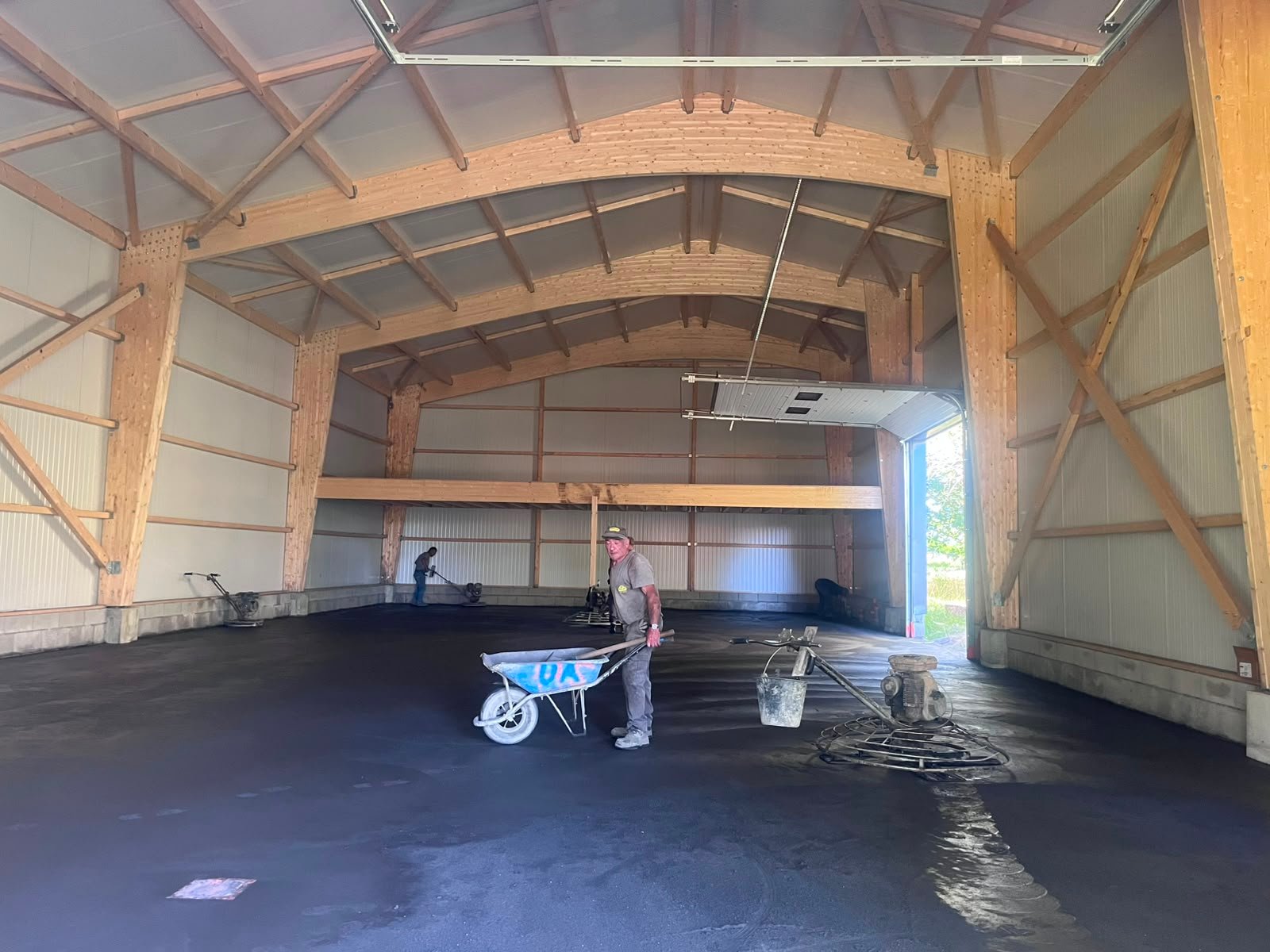 Intérieur du hangar — charpente bois et coulage de dalle